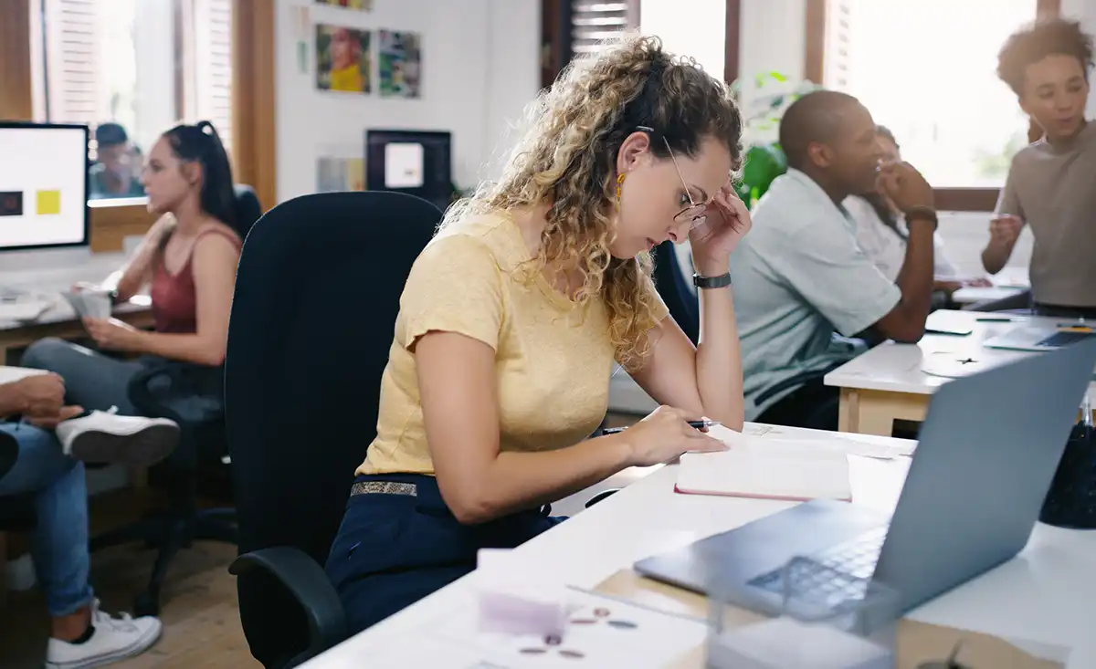 Fotografía de una profesora experimentando señales de burnout docente, como estrés y falta de energía